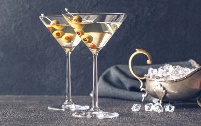 Two glasses of martini cocktail garnished with green olives